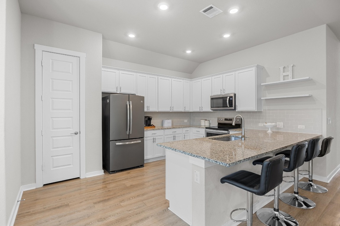 401 Peace Pipe Way Georgetown, TX 78628 - Photo 3 of 37 a kitchen with a refrigerator and a stove top oven