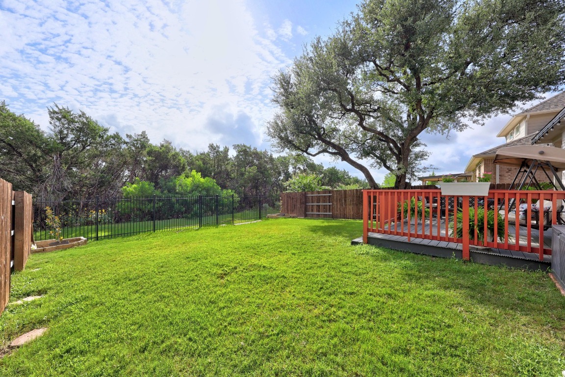 401 Peace Pipe Way Georgetown, TX 78628 - Photo 30 of 37 a view of a deck with a big yard potted plants and large tree
