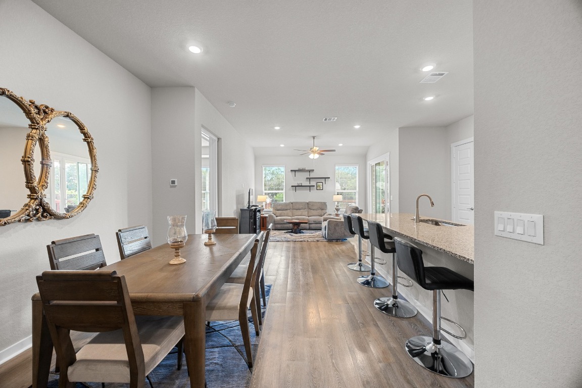 401 Peace Pipe Way Georgetown, TX 78628 - Photo 6 of 37 a view of a dining room with furniture and a wooden floor