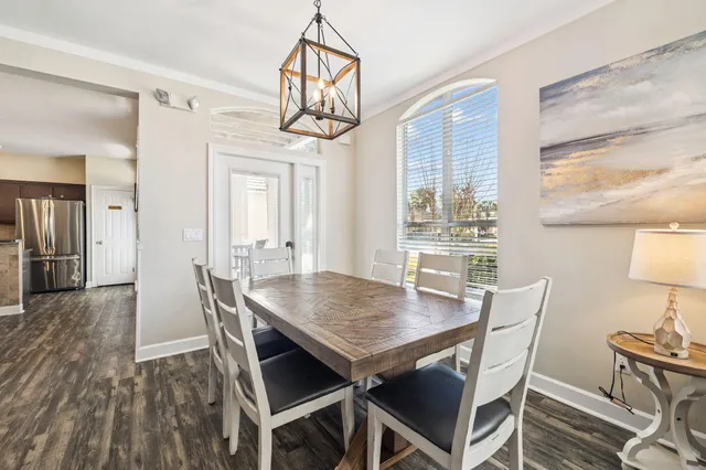 a dining room with furniture a chandelier and wooden floor