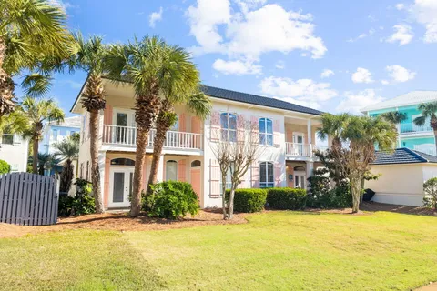 a front view of a house with a yard and palm trees