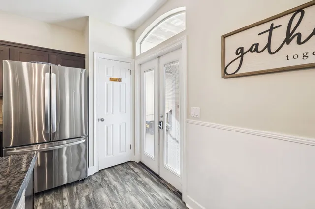 a kitchen with stainless steel appliances granite countertop a refrigerator a stove a sink and a wooden floors