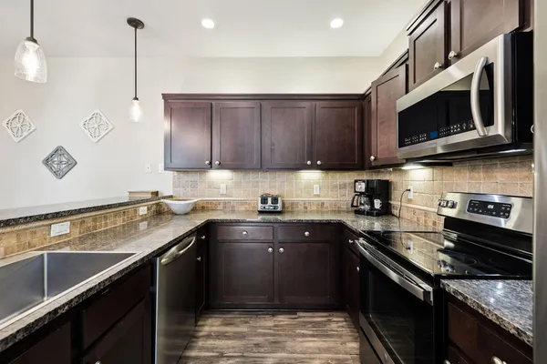 a kitchen with stainless steel appliances granite countertop a stove and a microwave
