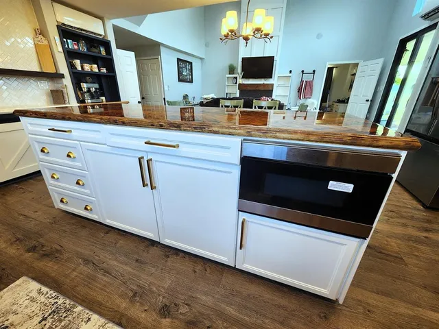 a room with kitchen island a sink and a stove with wooden floor