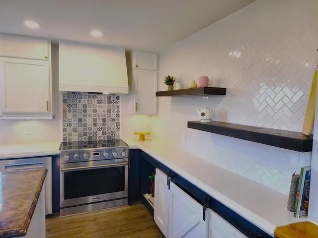 a kitchen with stainless steel appliances a stove a sink and a refrigerator