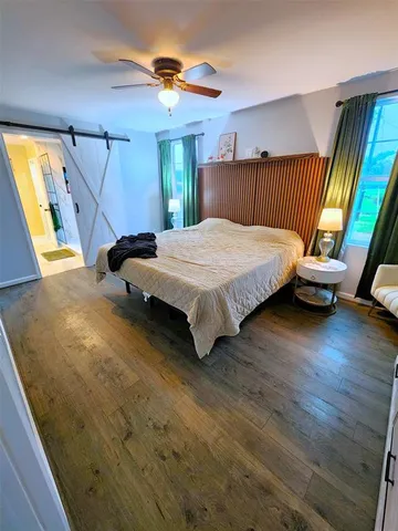a bedroom with a bed and wooden floor