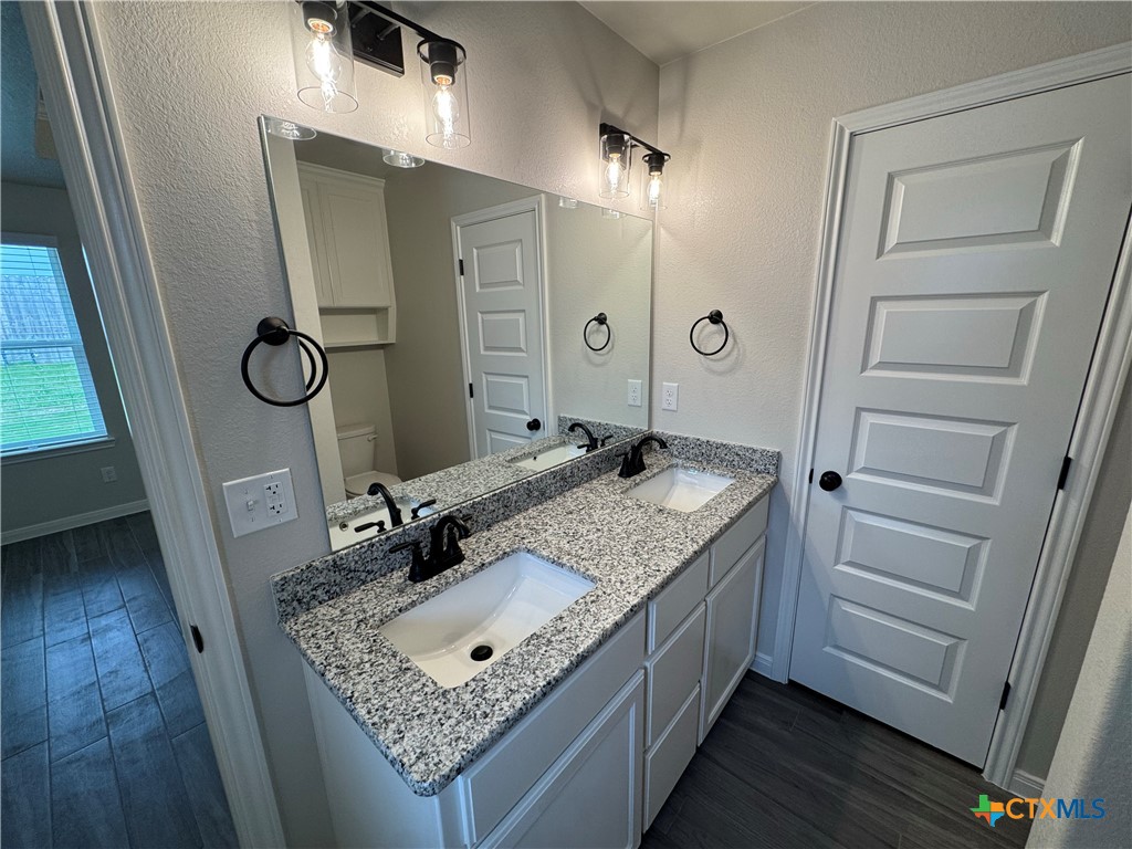 149 Atlas Avenue Killeen, TX 76542 - Photo 11 of 15 a bathroom with a granite countertop sink a mirror and shower