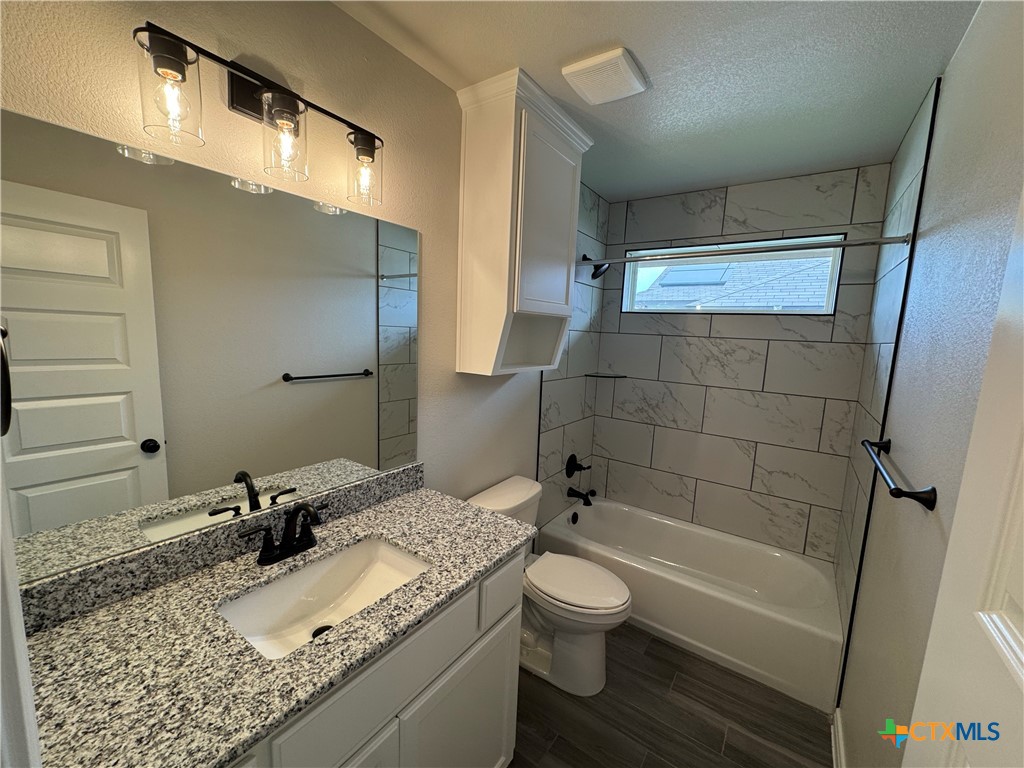 149 Atlas Avenue Killeen, TX 76542 - Photo 14 of 15 a bathroom with a granite countertop sink toilet and shower