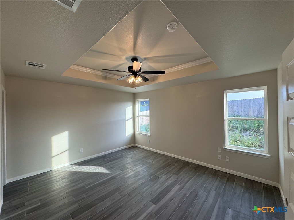 149 Atlas Avenue Killeen, TX 76542 - Photo 6 of 11 an empty room with wooden floor chandelier fan and windows