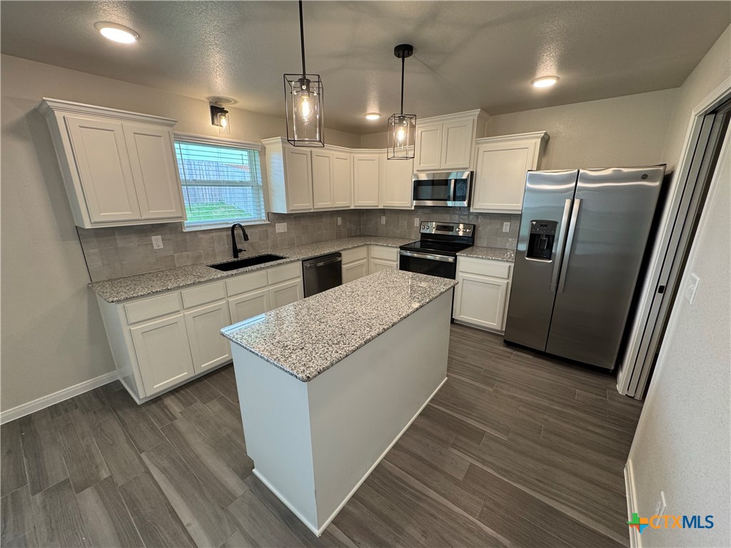 149 Atlas Avenue Killeen, TX 76542 - Photo 6 of 15 a kitchen with granite countertop a sink a counter top space stainless steel appliances and cabinets