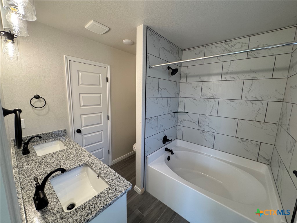 149 Atlas Avenue Killeen, TX 76542 - Photo 7 of 11 a bathroom with a granite countertop tub sink and mirror