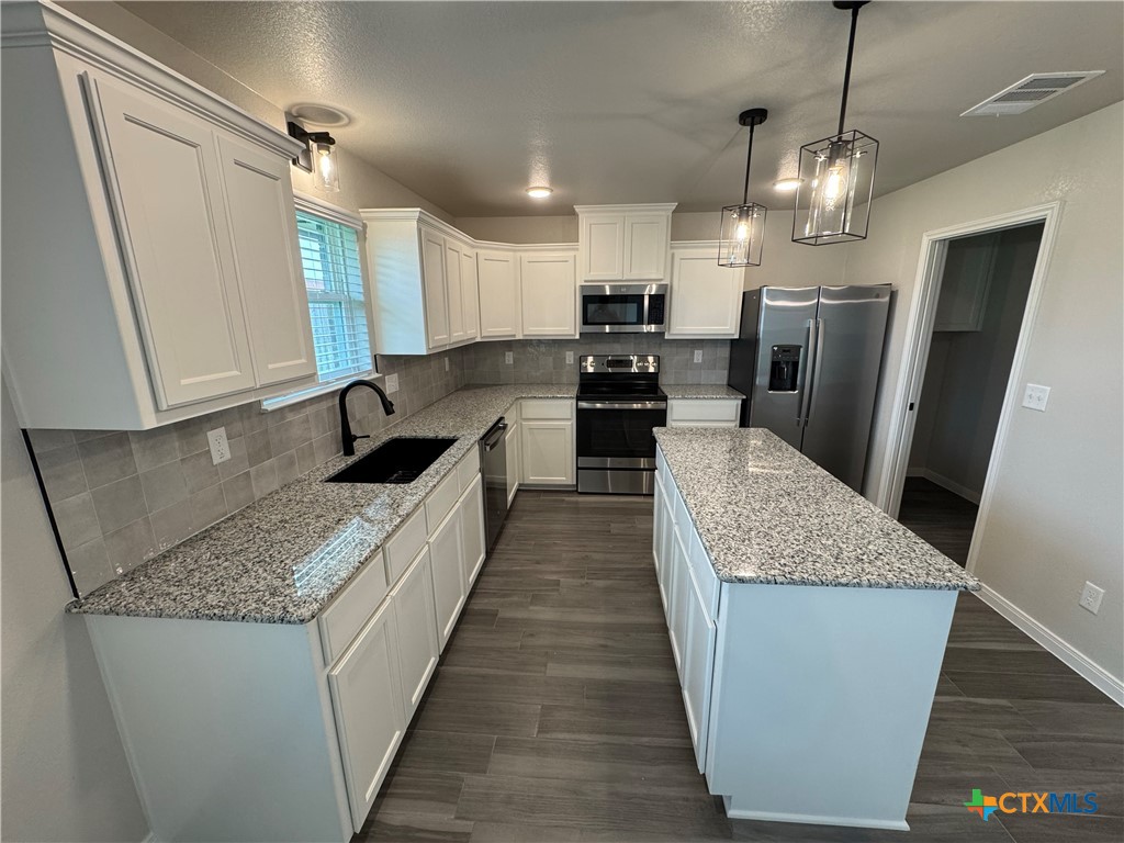 149 Atlas Avenue Killeen, TX 76542 - Photo 7 of 15 a large kitchen with a center island wooden floor and stainless steel appliances