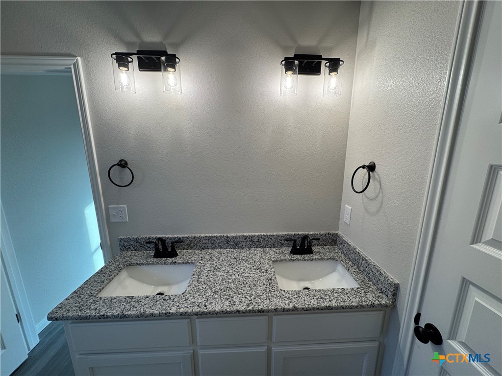 149 Atlas Avenue Killeen, TX 76542 - Photo 8 of 11 a bathroom with a granite countertop sink and a mirror