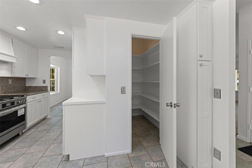 175 Wrangler Road Simi Valley, CA 93065 - Photo 14 of 52 a kitchen with a refrigerator and white cabinets