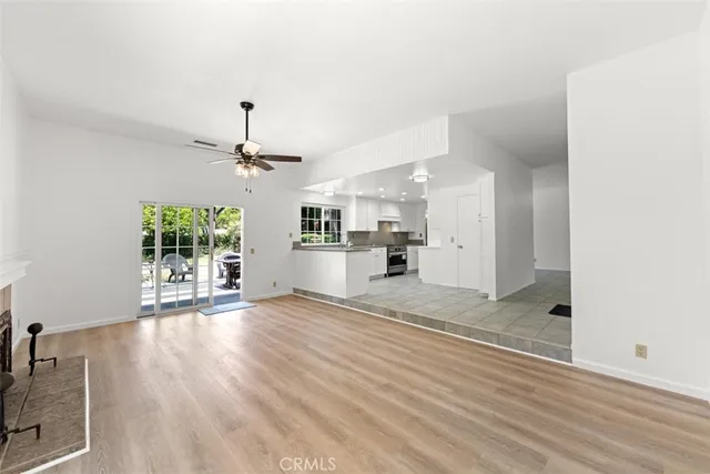 a view of a living room and kitchen with wooden floor