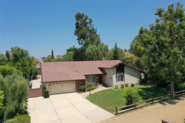 a aerial view of a house with yard and large trees