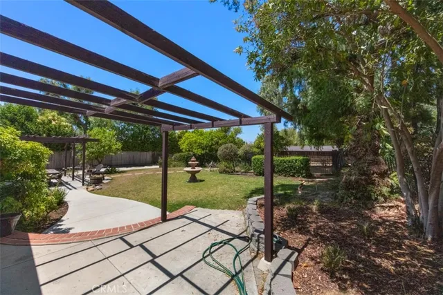 a view of a backyard with table and chairs under an umbrella