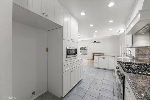 a kitchen with white cabinets and appliances