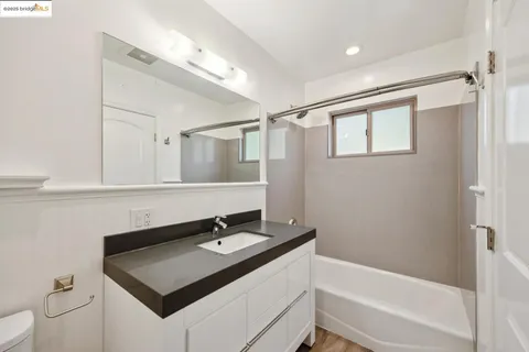a bathroom with a sink vanity tub and shower