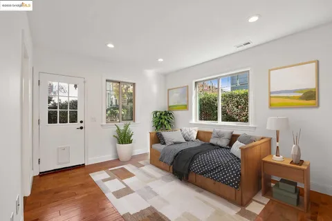 an empty room with wooden floor & windows and bathroom