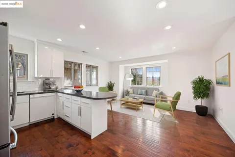 a kitchen with granite countertop white cabinets and wooden floor