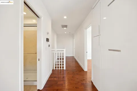 a view of a hallway with wooden floor and staircase