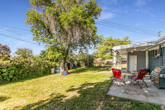 1619 Davis Drive Layton, UT 84041 - Photo 25 of 27 Spacious backyard featuring a covered patio, expansive lawn, mature shade tree, and detached storage shed