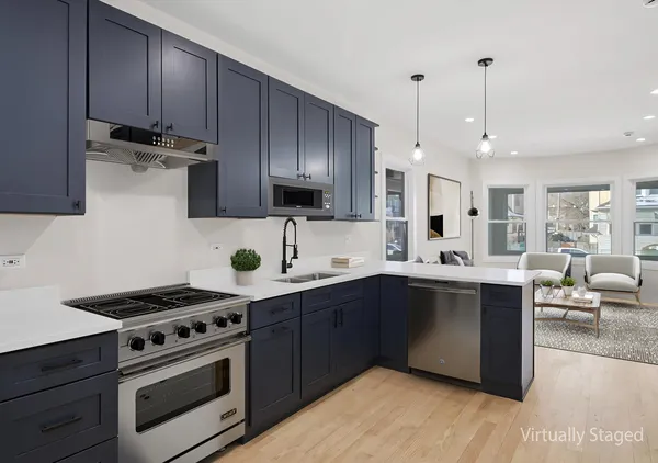 a kitchen with stainless steel appliances a stove a sink and a refrigerator