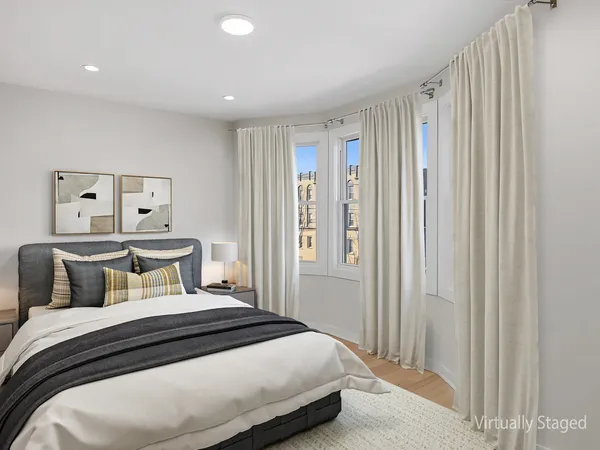 a bedroom with a bed and painting on the wall