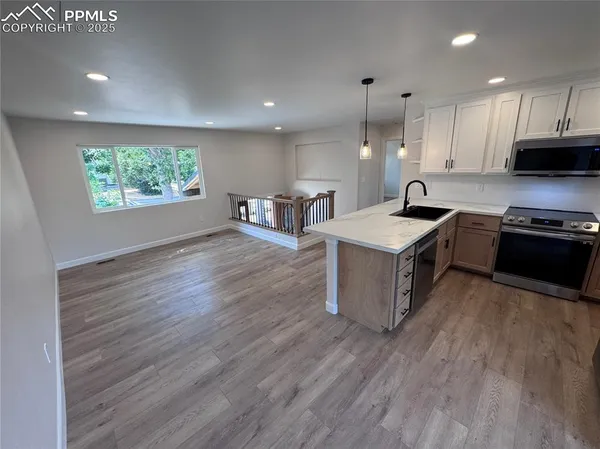 a kitchen with stainless steel appliances granite countertop a stove a sink and a refrigerator