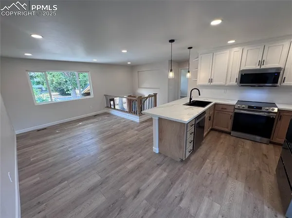 a kitchen with stainless steel appliances granite countertop a stove a sink and a refrigerator