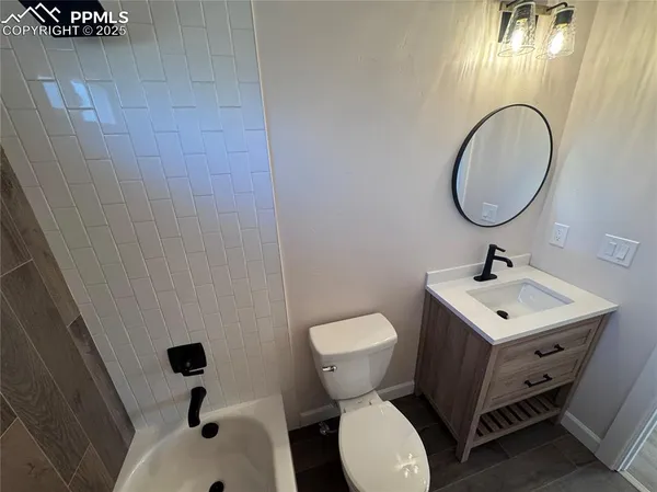 a bathroom with a toilet a sink and mirror