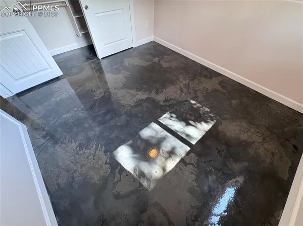an empty room with wooden floor and mirror