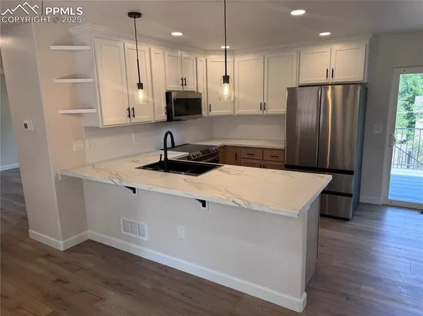 a kitchen with stainless steel appliances a refrigerator sink and wooden cabinets