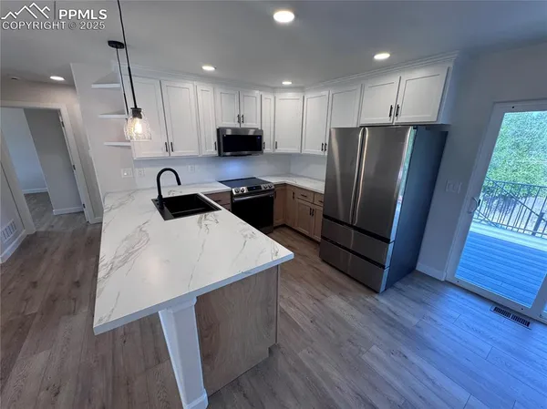 a kitchen with wooden floors and refrigerator