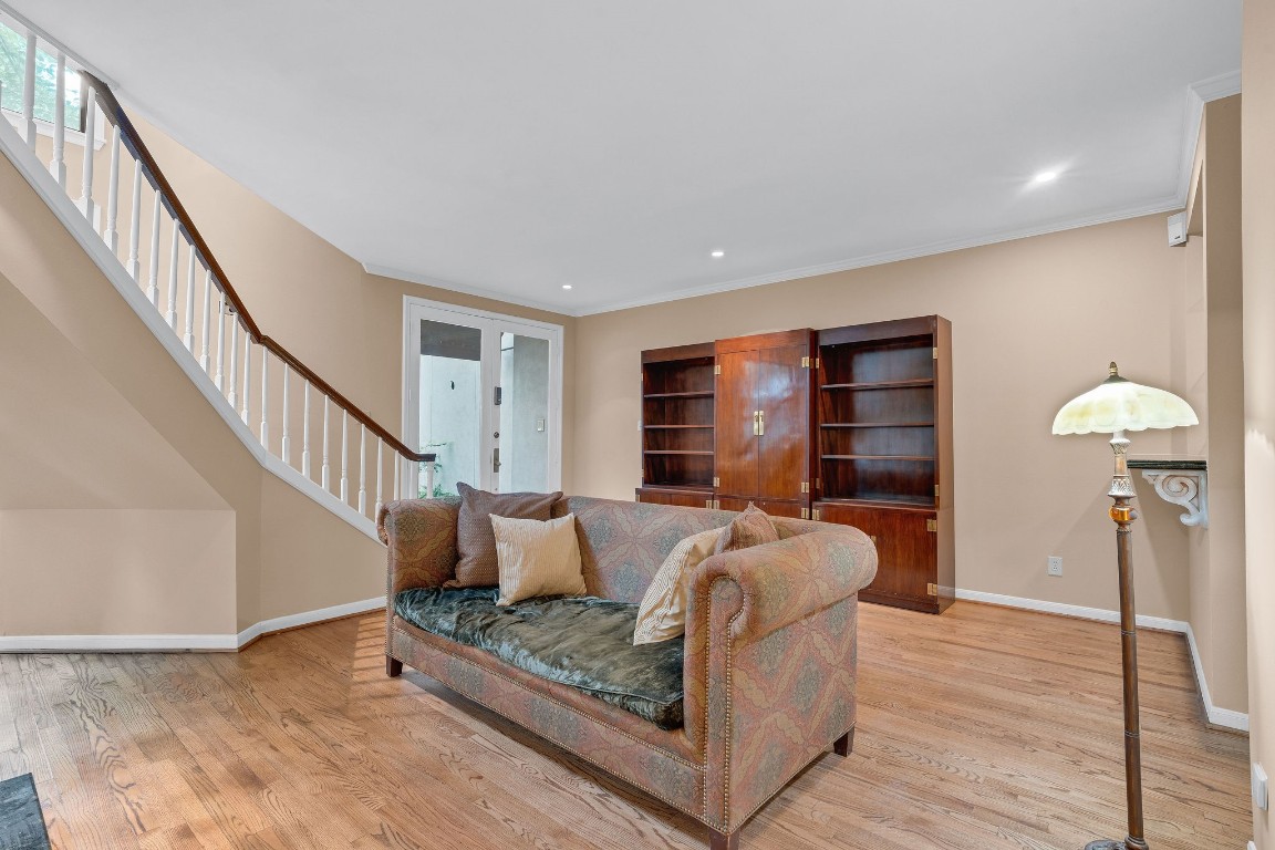 5084 Augusta Street Houston, TX 77007 - Photo 11 of 43 The living room features hardwood floors, a cozy fireplace, and an elegant staircase. The open layout offers ample space, complemented by neutral walls and natural light.