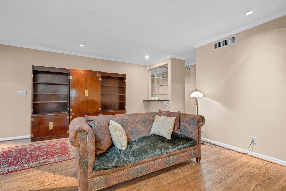 5084 Augusta Street Houston, TX 77007 - Photo 13 of 43 The living room features hardwood floors, a cozy fireplace, and an elegant staircase. The open layout offers ample space, complemented by neutral walls and natural light.