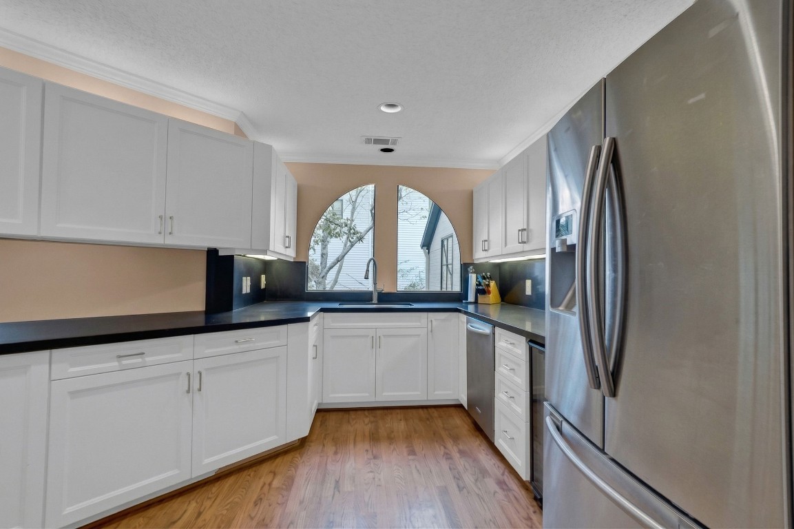 5084 Augusta Street Houston, TX 77007 - Photo 19 of 43 a kitchen with granite countertop a refrigerator sink and white cabinets