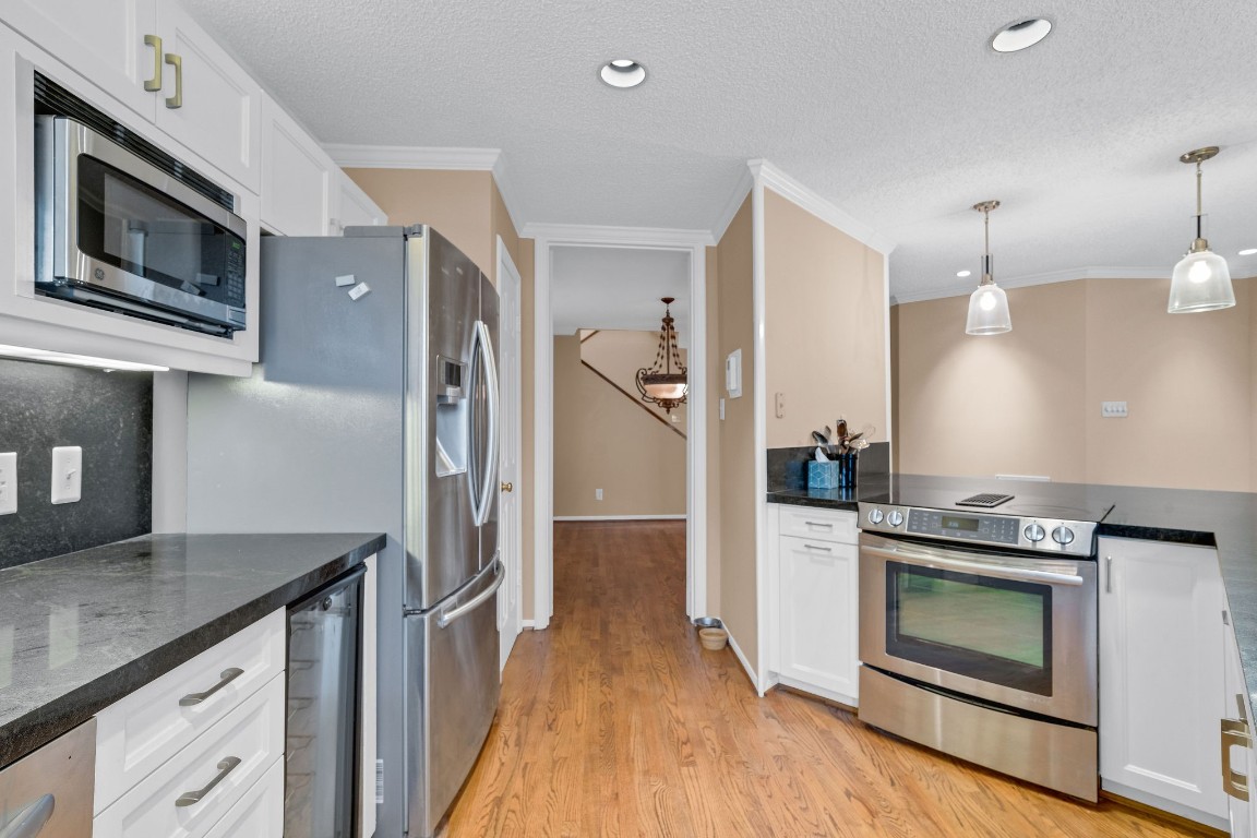 5084 Augusta Street Houston, TX 77007 - Photo 21 of 43 a kitchen with stainless steel appliances granite countertop a stove a refrigerator and a microwave