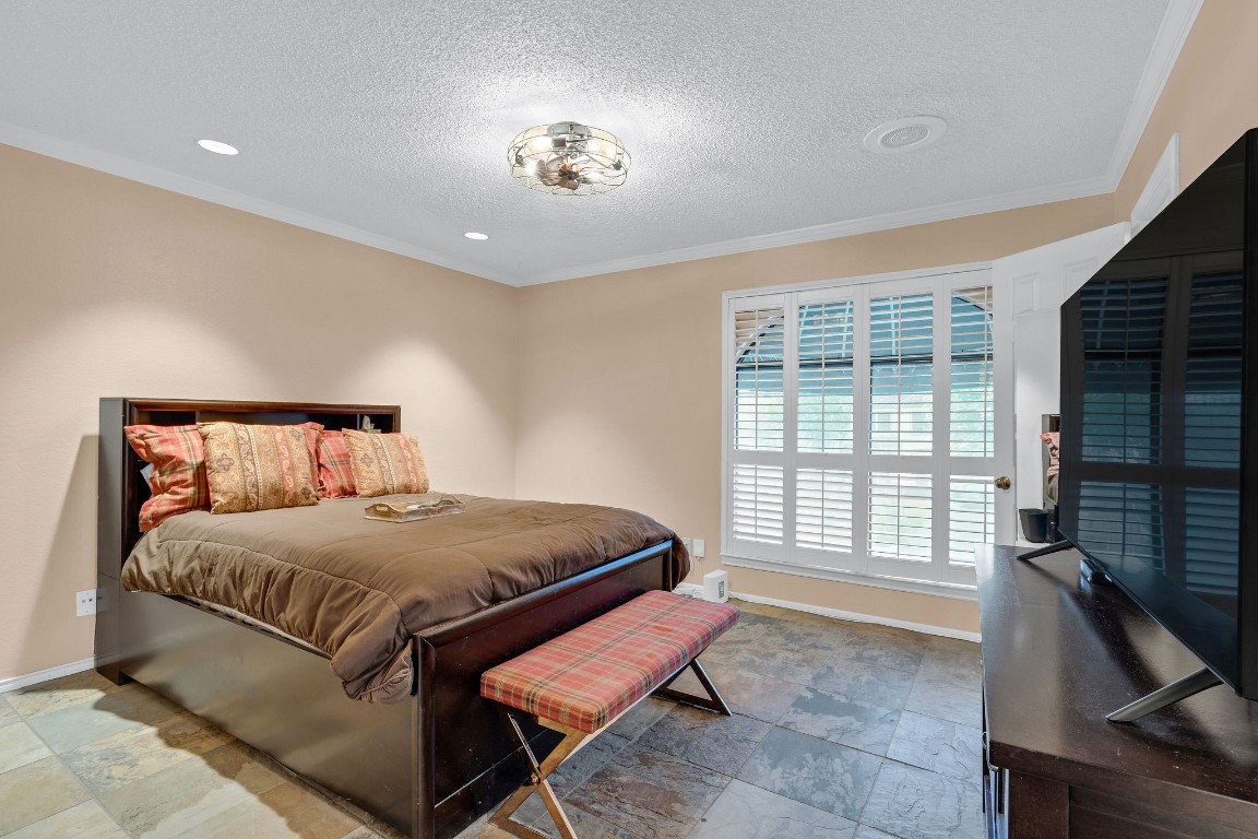5084 Augusta Street Houston, TX 77007 - Photo 27 of 43 Guest bedroom. Window with plantation shutters allowing natural light. The space is enhanced by recessed lighting and a stylish ceiling fixture.