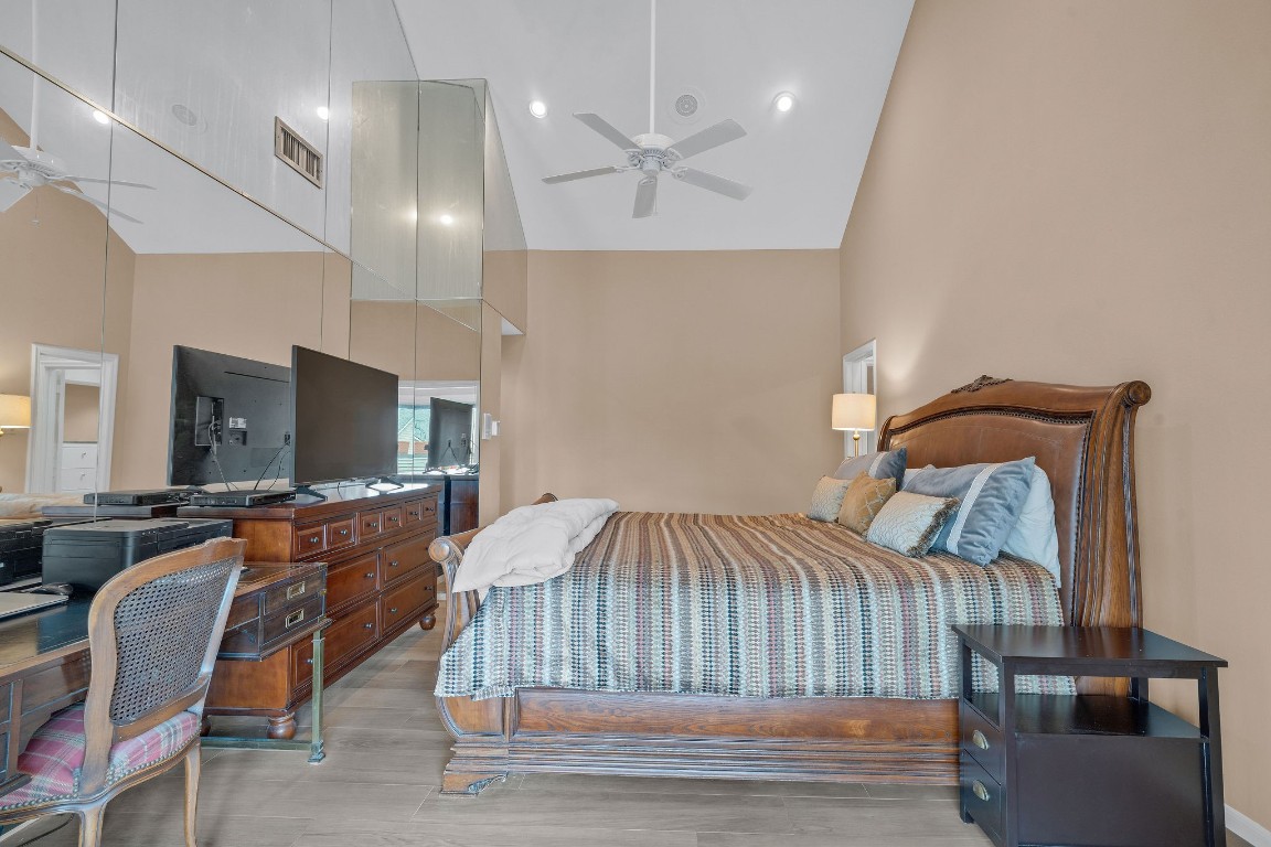 5084 Augusta Street Houston, TX 77007 - Photo 32 of 43 Spacious primary bedroom featuring high vaulted ceilings, and a large mirrored wall.