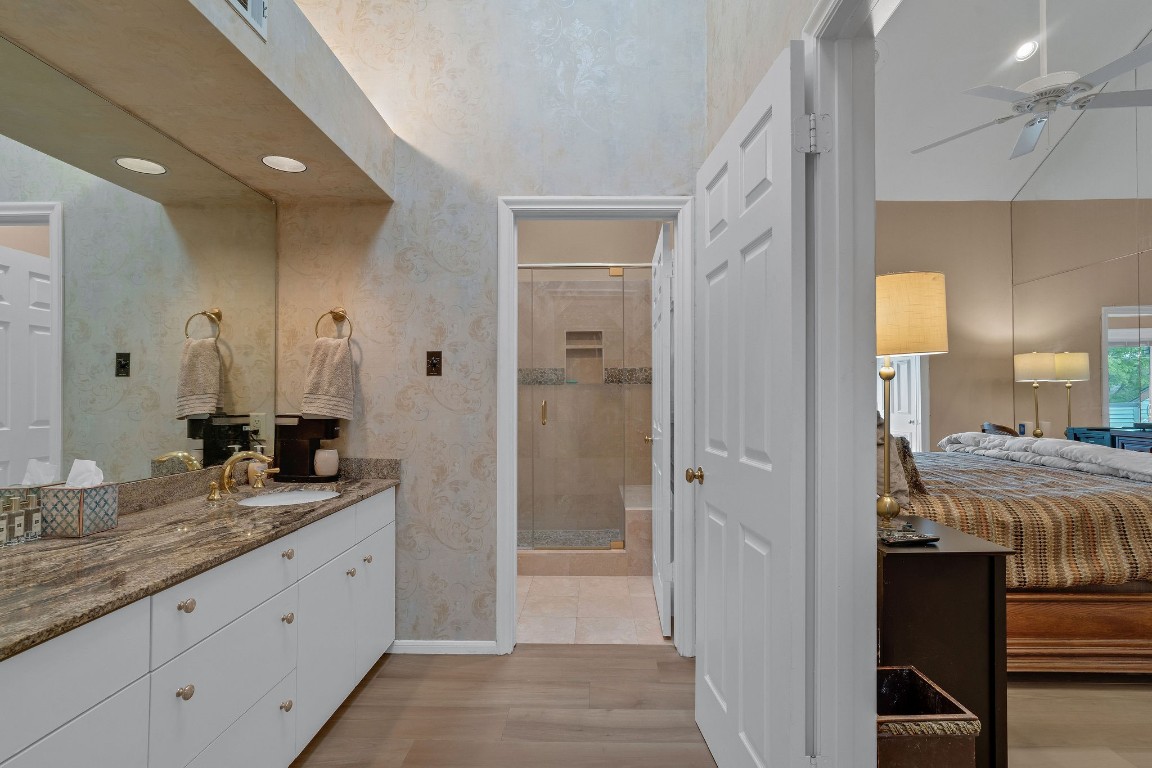 5084 Augusta Street Houston, TX 77007 - Photo 40 of 43 a bathroom with a granite countertop sink mirror and a shower