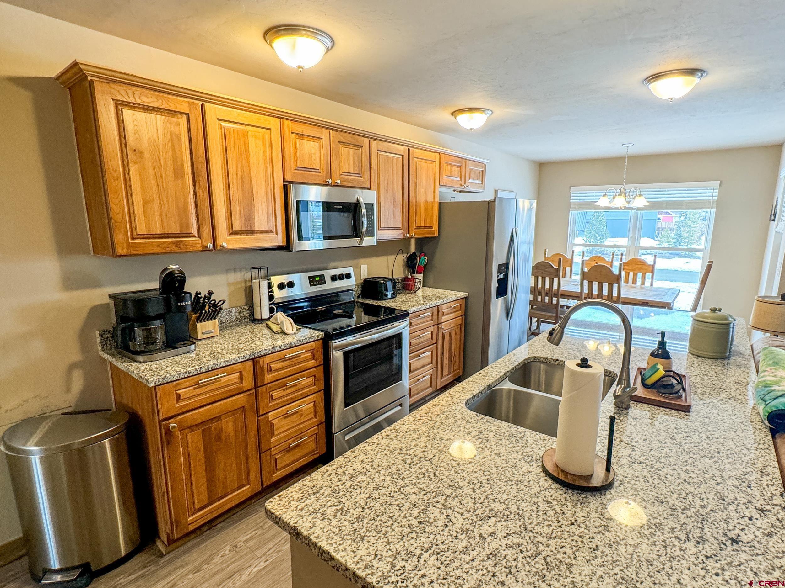 100 Teocalli Road, Unit 2 Crested Butte, CO 81224 - Photo 3 of 37 a kitchen with granite countertop a sink a counter top space appliances and cabinets