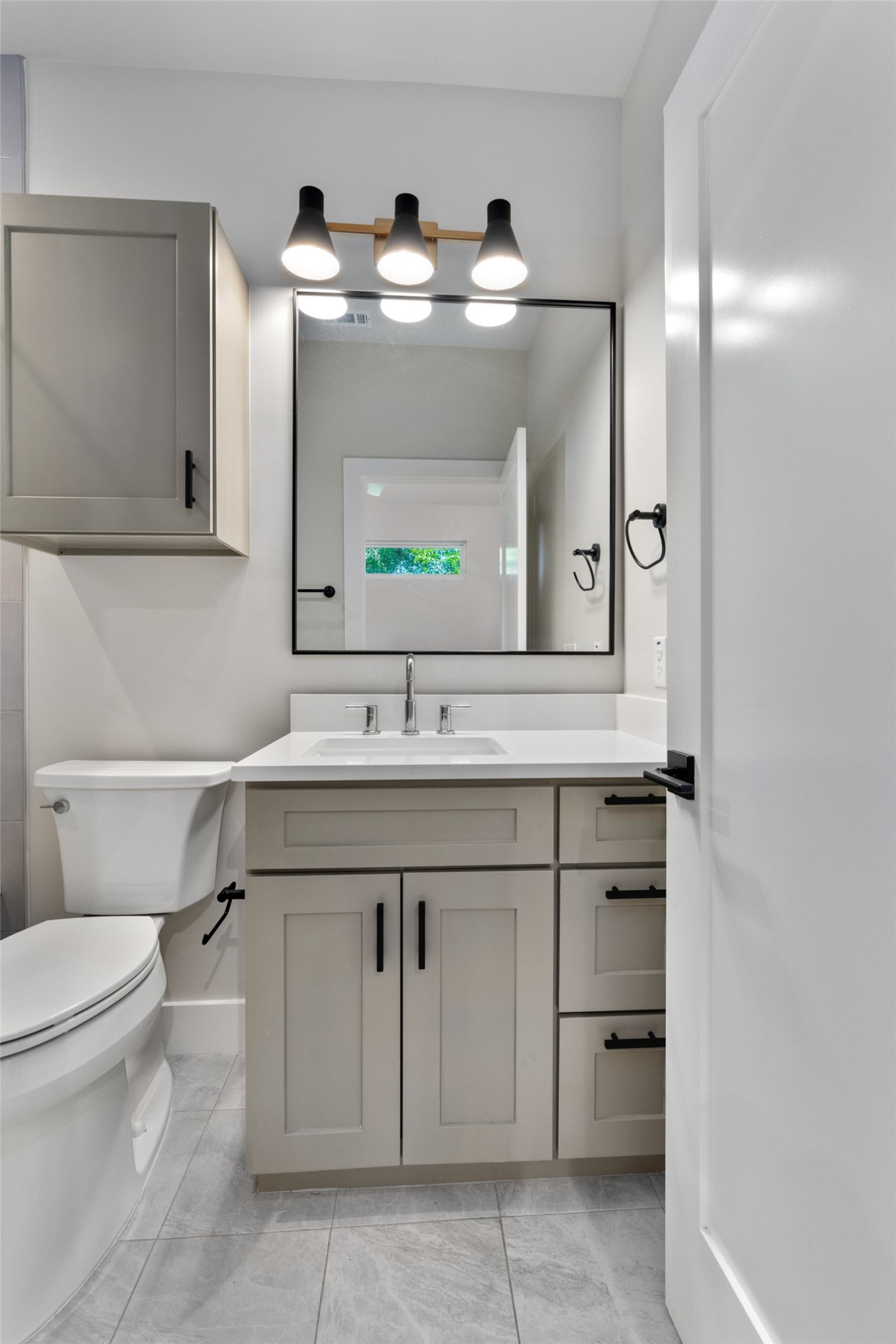 5200 Grover Avenue Austin, TX 78756 - Photo 19 of 32 Contemporary primary bathroom vanity featuring light gray cabinetry, white countertop, and integrated sink