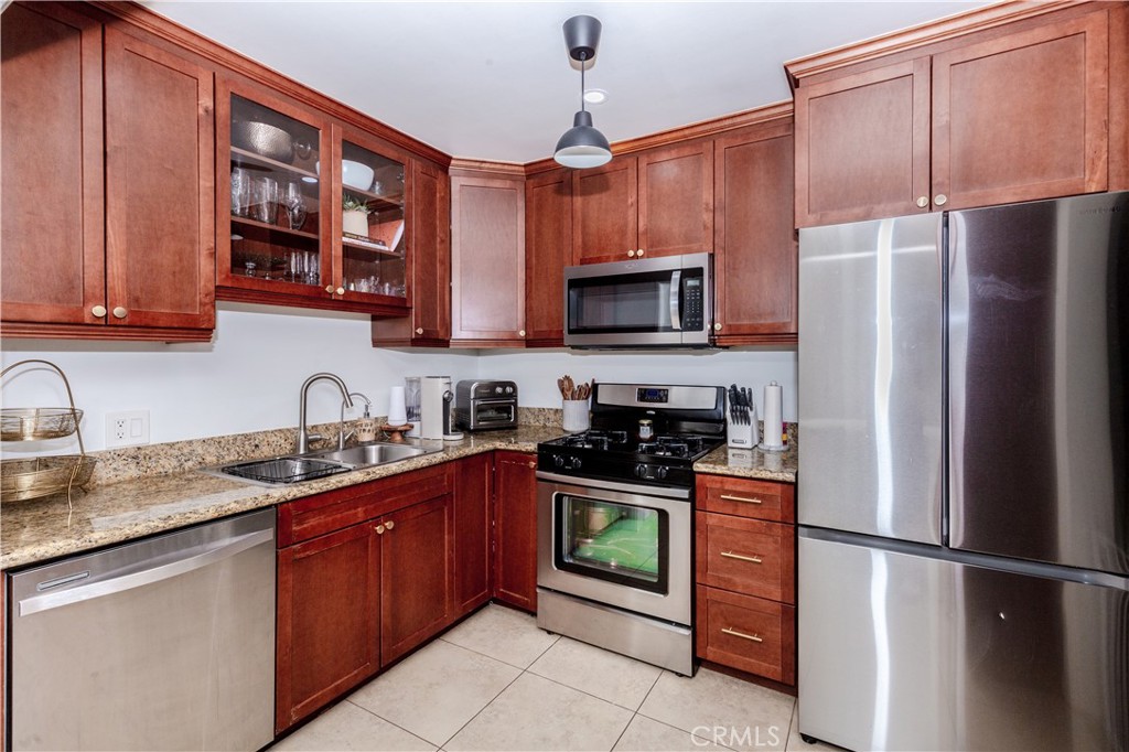 7734 Sycamore Avenue Riverside, CA 92504 - Photo 15 of 47 a kitchen with stainless steel appliances granite countertop a refrigerator stove microwave and sink