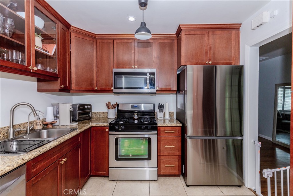 7734 Sycamore Avenue Riverside, CA 92504 - Photo 17 of 47 a kitchen with stainless steel appliances granite countertop a refrigerator and a stove top oven