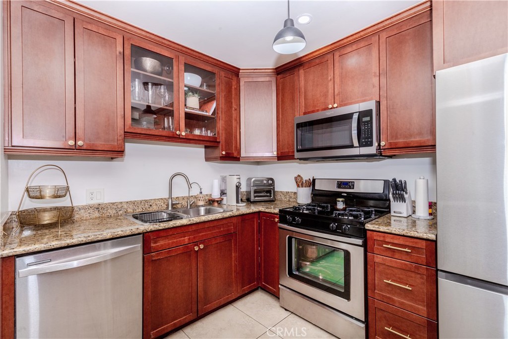 7734 Sycamore Avenue Riverside, CA 92504 - Photo 20 of 47 a kitchen with stainless steel appliances granite countertop a stove sink microwave and cabinets