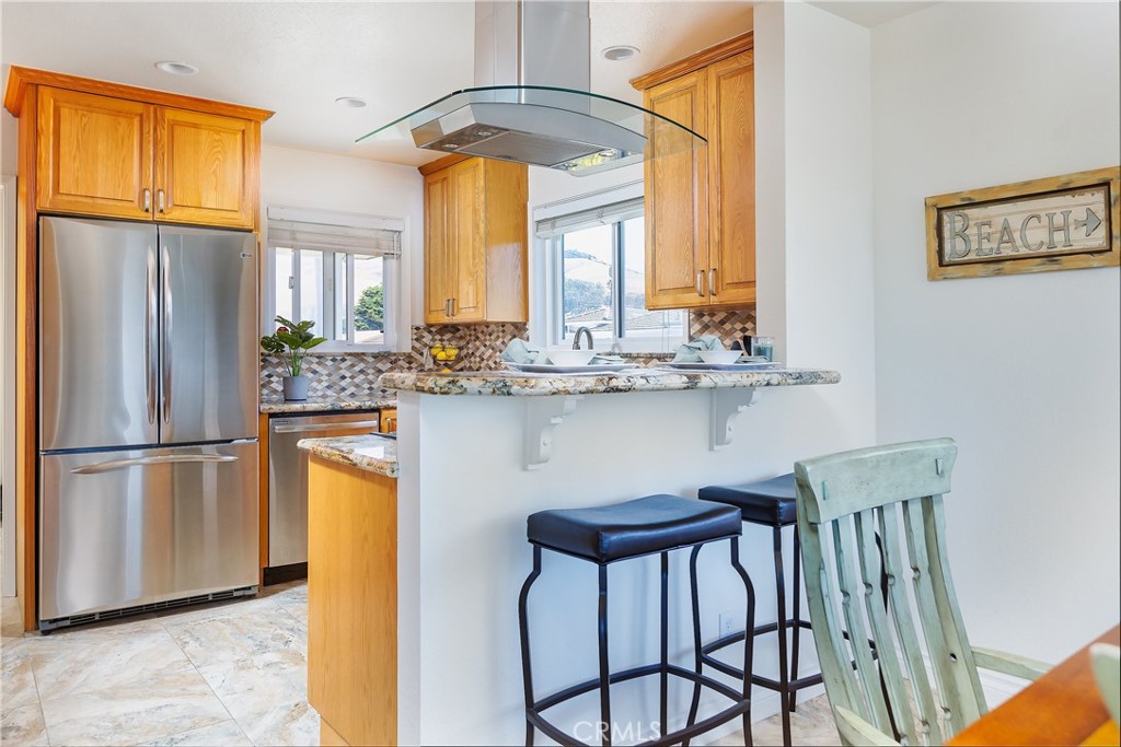 101 Java Street Morro Bay, CA 93442 - Photo 13 of 29 a kitchen with stainless steel appliances white cabinets and a refrigerator