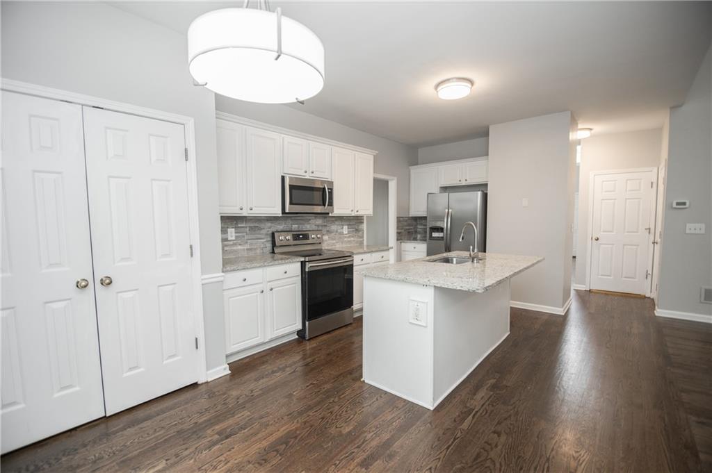 755 Sheridan Ridge Court Alpharetta, GA 30022 - Photo 12 of 57 a kitchen with a sink cabinets and wooden floor
