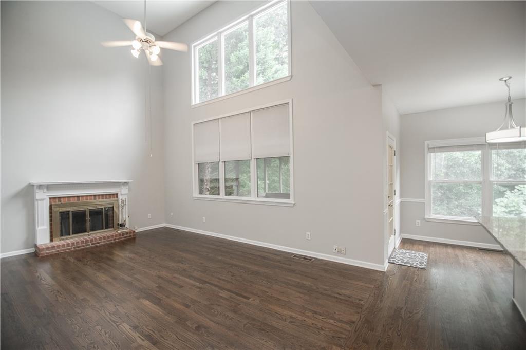 755 Sheridan Ridge Court Alpharetta, GA 30022 - Photo 16 of 57 an empty room with wooden floor fireplace and windows
